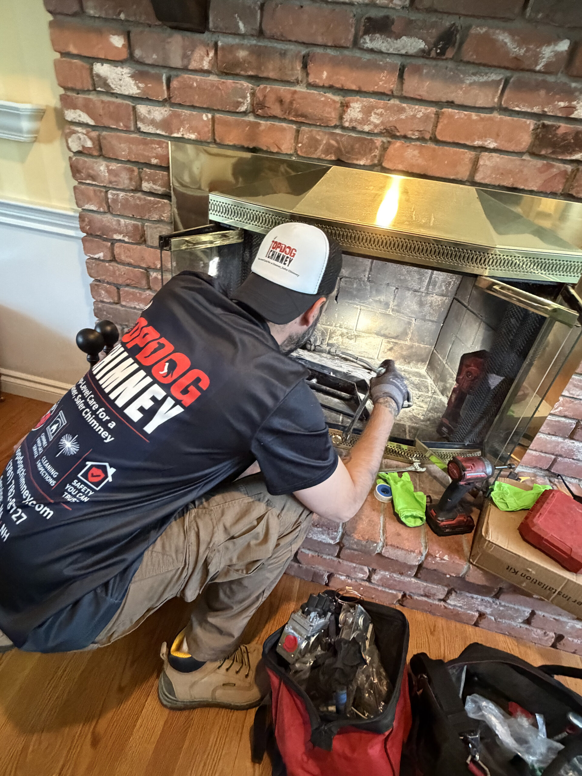 TopDog Chimney technician repairing a brick fireplace and firebox inside a home