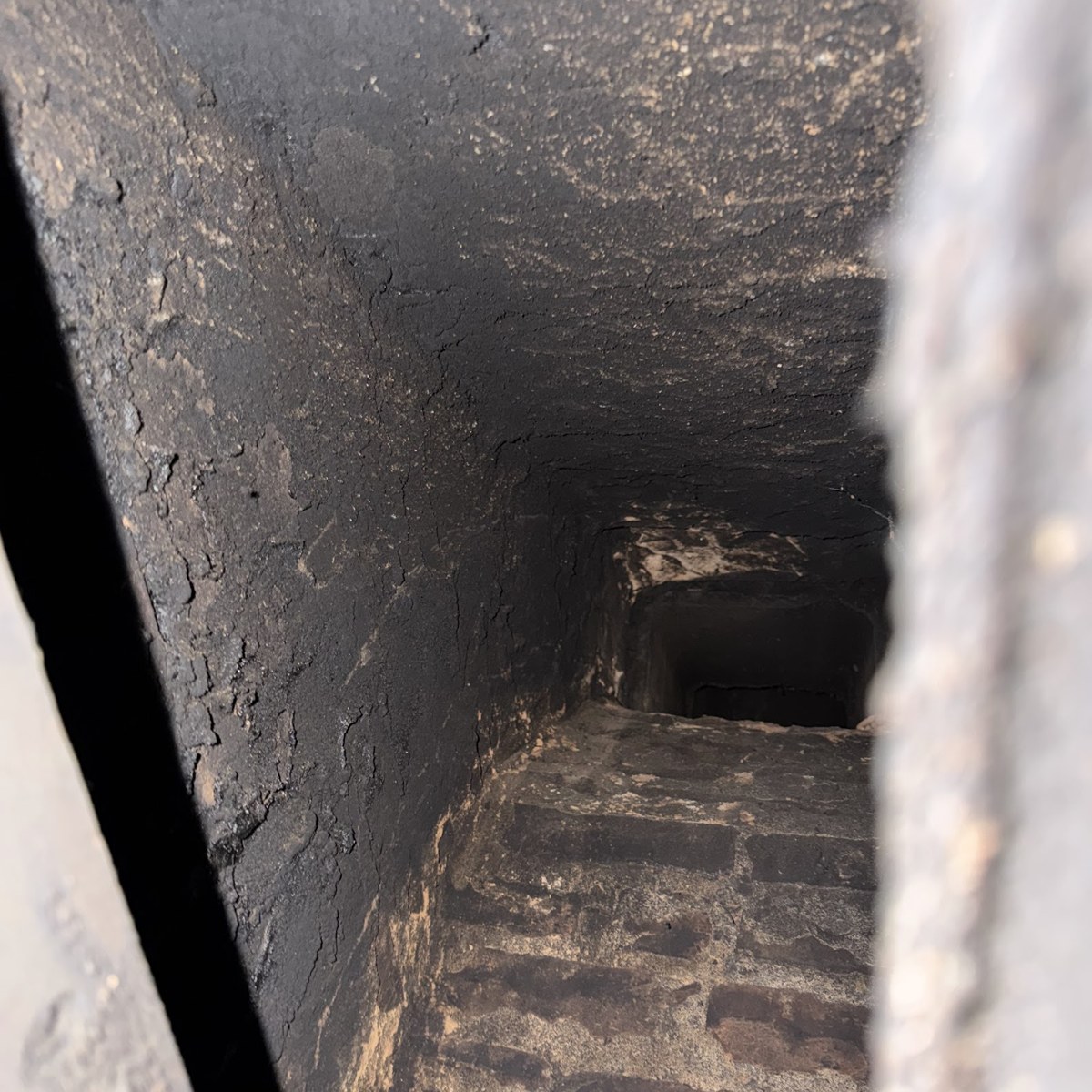 Deteriorated smoke chamber with sooty, crumbling corbeled brick before repair by TopDog Chimney